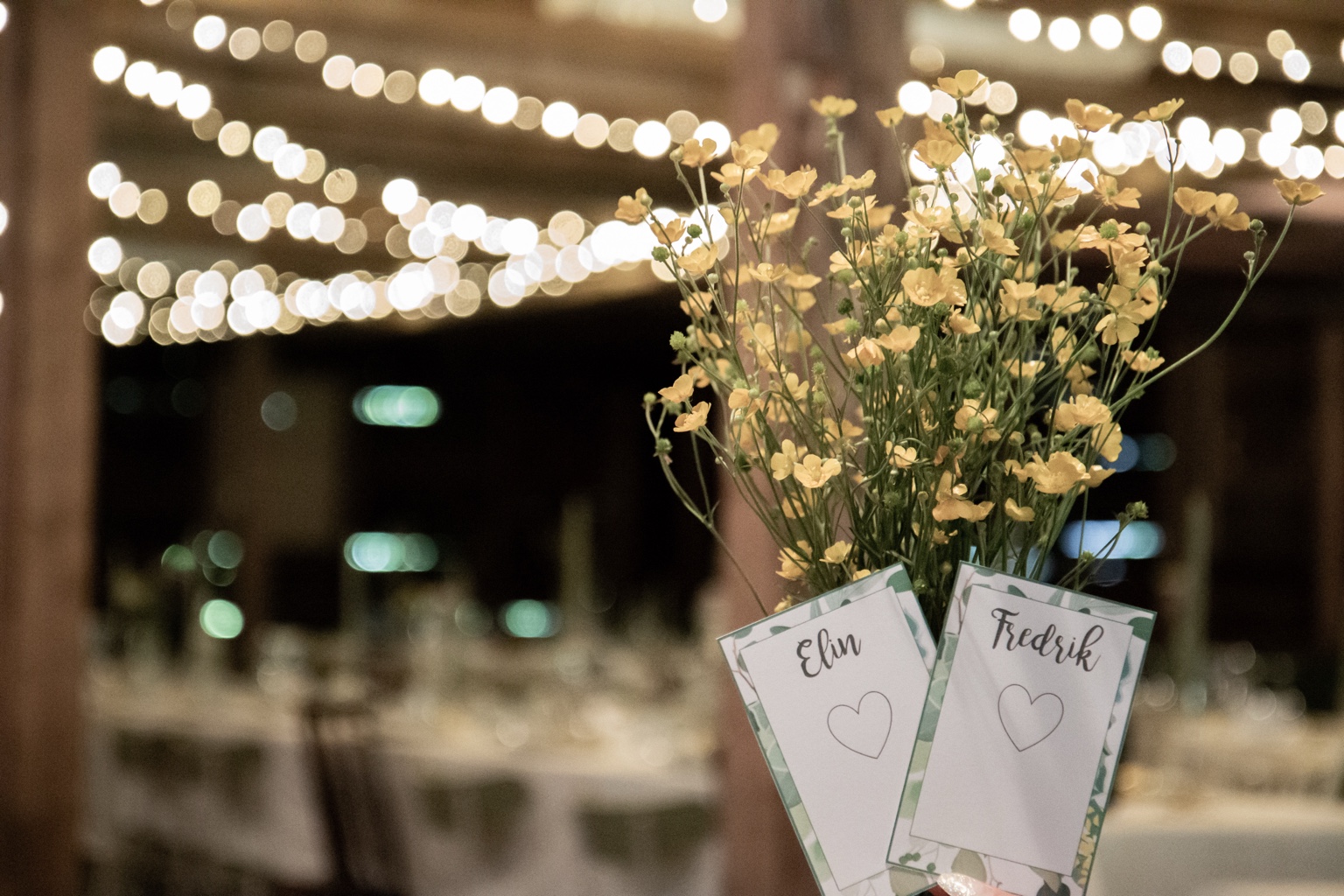 Blommor och placeringskort i festlokalens kvällsljus
